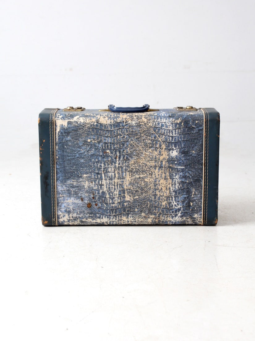 Mid-Century Vacationer Blue Hard-Shell Suitcase with Faux Alligator Texture: Mid-Century Vacationer Blue Hard-Shell Suitcase with Faux Alligator Texture Discover this charming mid-century Vacationer hard-shell suitcase, showcasing a distinctive blue colorway. The suitcase feat