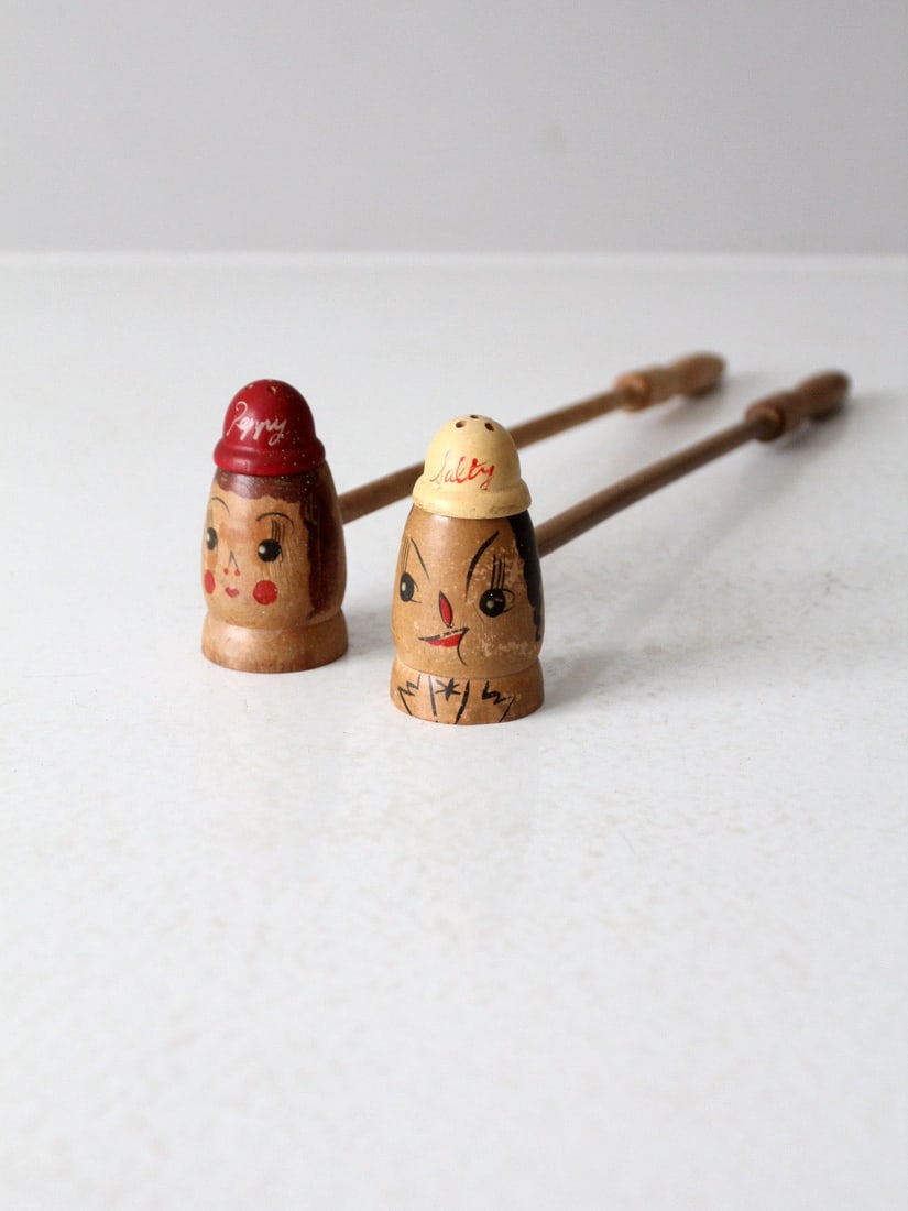 Pair of Hand Painted Midcentury Wood Salt and Pepper Shakers with Figural Faces: Pair of Hand Painted Midcentury Wood Salt and Pepper Shakers with Figural Faces This mid-century pair of wooden salt and pepper shakers features hand-painted figural faces labeled "Peppry" and "Salty.