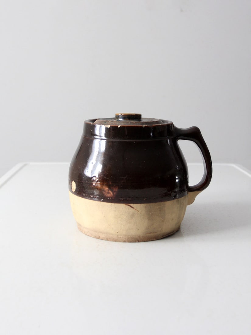 Antique Early 20th Century Stoneware Bean Pot with Brown Albany Slip Glaze: Antique Early 20th Century Stoneware Bean Pot with Brown Albany Slip Glaze This antique stoneware bean pot from the early 20th century showcases a classic pitcher-style handle and an inset lid with a