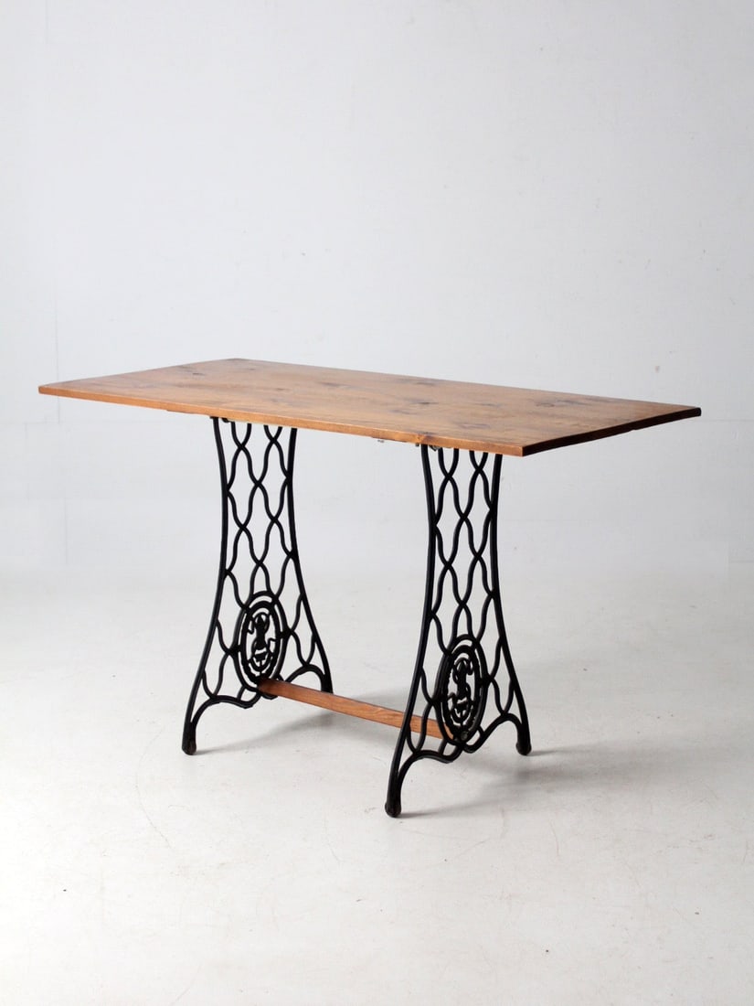 Antique Sewing Machine Base Table With Wooden Top Industrial Style: Antique Sewing Machine Base Table With Wooden Top Industrial Style This vintage table combines an antique Singer cast iron sewing machine base with a wood top, creating a striking industrial aesthetic
