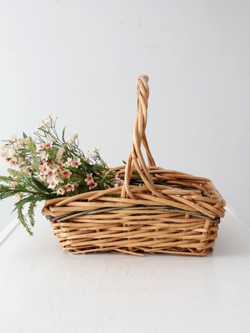 Vintage Woven Wicker Gathering Basket with Twisted Handle: Vintage Woven Wicker Gathering Basket with Twisted Handle This vintage woven wicker basket showcases a classic harvest design, complete with a twisted handle and intricate weave. It serves as a stylis