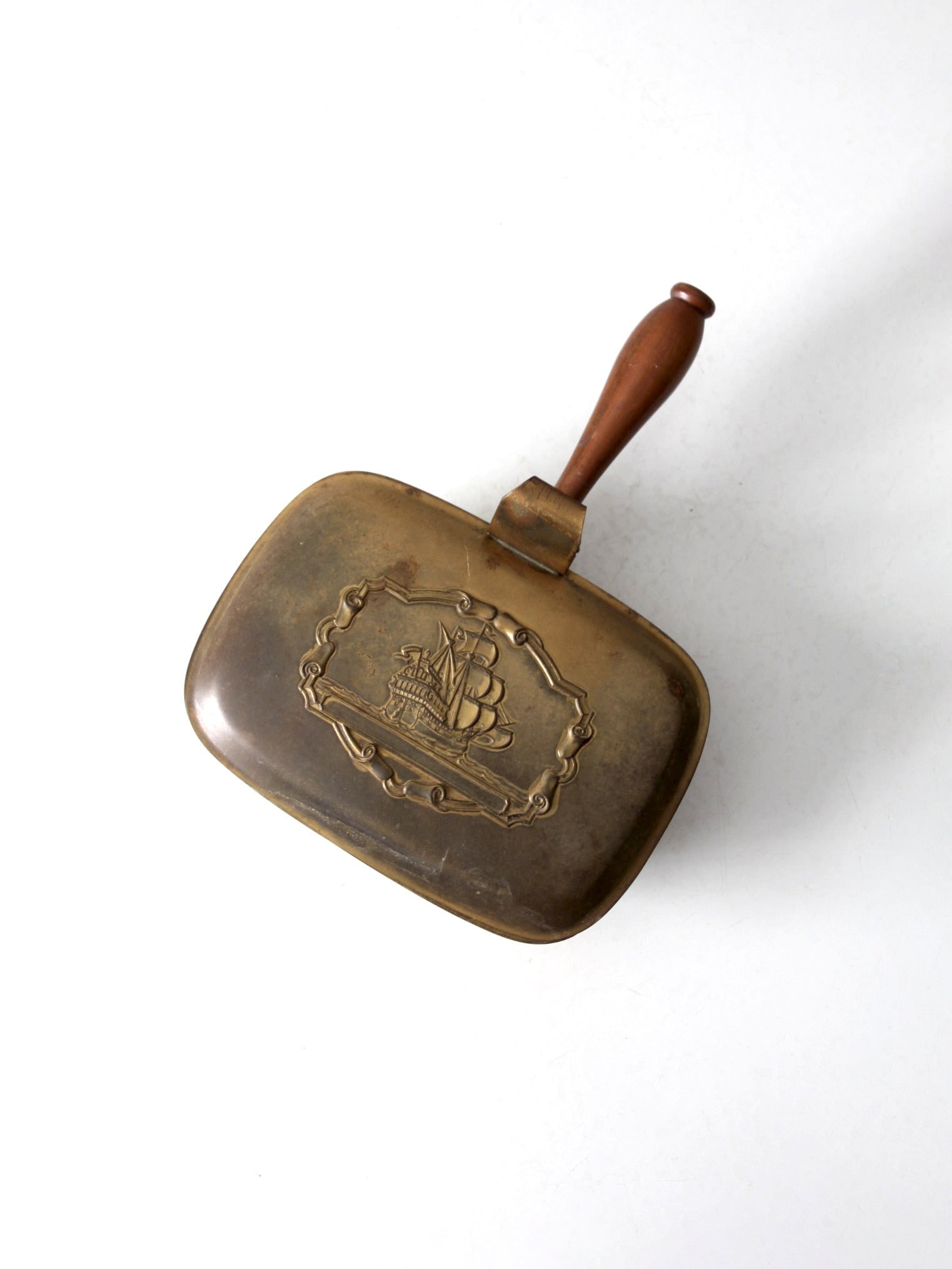 Vintage Brass Silent Butler with Ornate Ship Design: Vintage Brass Silent Butler with Ornate Ship Design This vintage brass silent butler features an embossed ship design framed by an ornate scroll border. The hinged lid opens to reveal a smooth interio