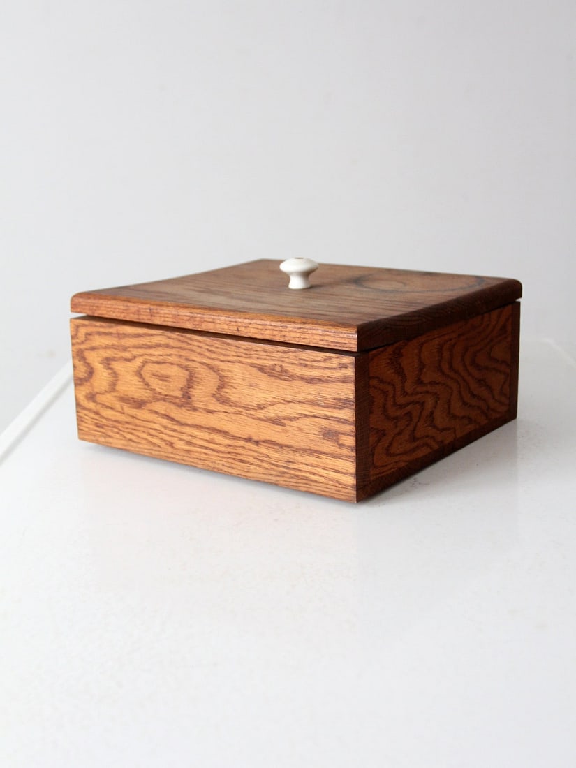 Rustic Vintage Oak Wood Storage Box with White Knob: Rustic Vintage Oak Wood Storage Box with White Knob This vintage oak wood storage box showcases a clean square design, complemented by a white knob for easy opening. The rustic wood surface enhances i