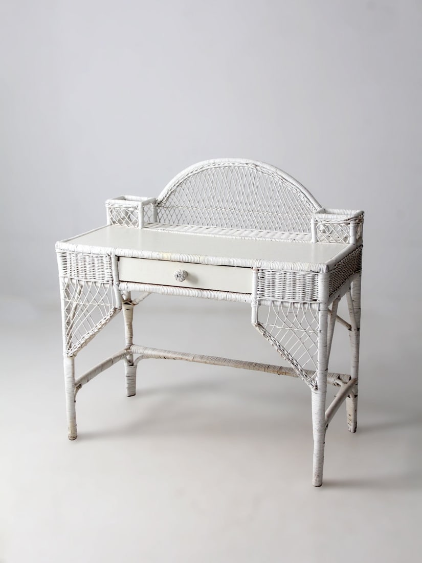 American Wicker Writing Desk with Drawer Early 1900s White Finish: American Wicker Writing Desk with Drawer Early 1900s White Finish This early 20th-century American wicker desk features a balanced silhouette and woven construction, giving it a light and airy appeara