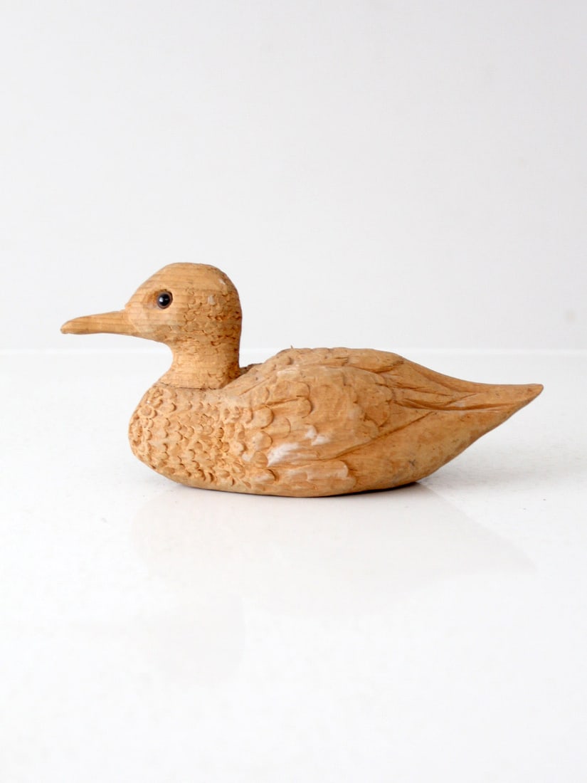 Vintage Hand-Carved Wooden Duck with Glass Eyes Signed by Artist: Vintage Hand-Carved Wooden Duck with Glass Eyes Signed by Artist This vintage hand-carved wooden duck showcases intricate rustic details and a natural unpainted finish. The glass eyes provide a charmi