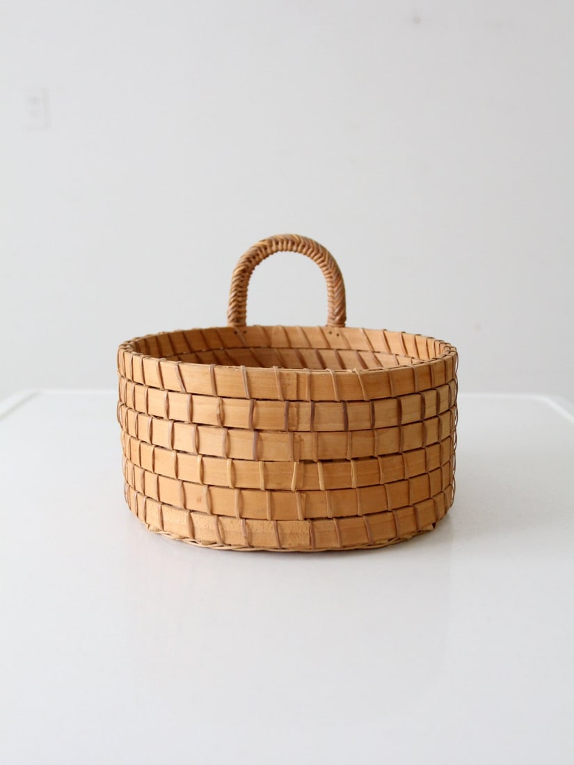 Unique Vintage Handwoven Round Catchall Basket with Handle: Unique Vintage Handwoven Round Catchall Basket with Handle This vintage handwoven catchall basket is a unique addition to any home decor. Featuring a round shape with an unusual stacked bentwood strip
