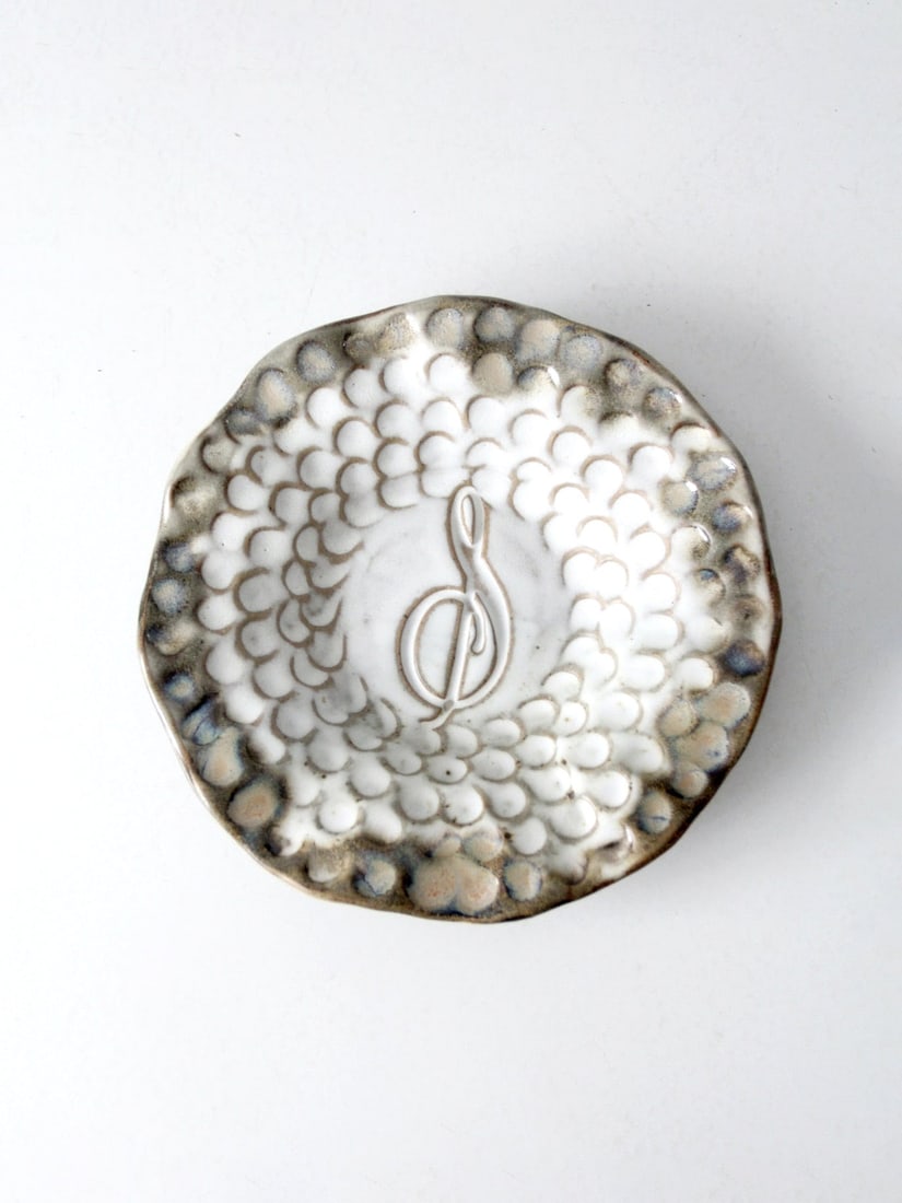 Signed Vintage Studio Pottery Plate with Scallop Edge and Clef Note: Signed Vintage Studio Pottery Plate with Scallop Edge and Clef Note This vintage studio pottery plate showcases a unique handmade design, featuring a scallop edge and a central etched clef note. It is