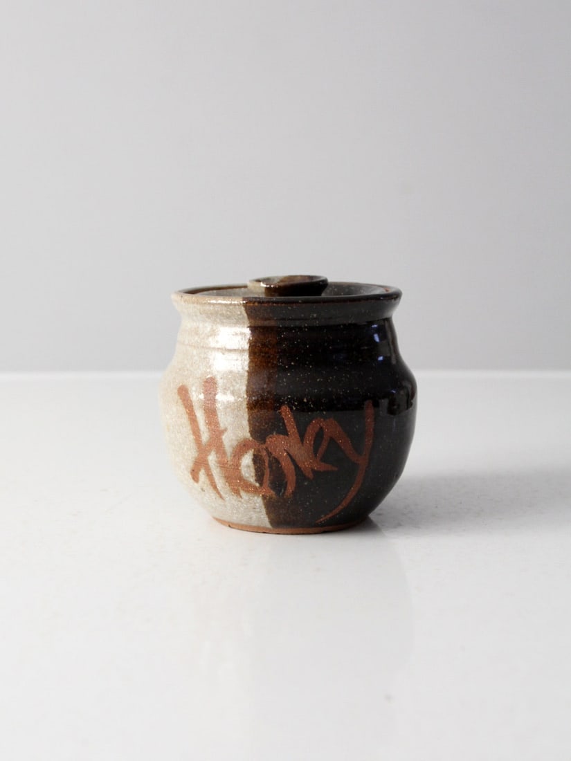Vintage 70s Handcrafted Studio Pottery Honey Pot Signed: Vintage 70s Handcrafted Studio Pottery Honey Pot Signed This vintage studio pottery honey pot is a charming addition to any collection. Handcrafted by an artist and signed with the date, it features a