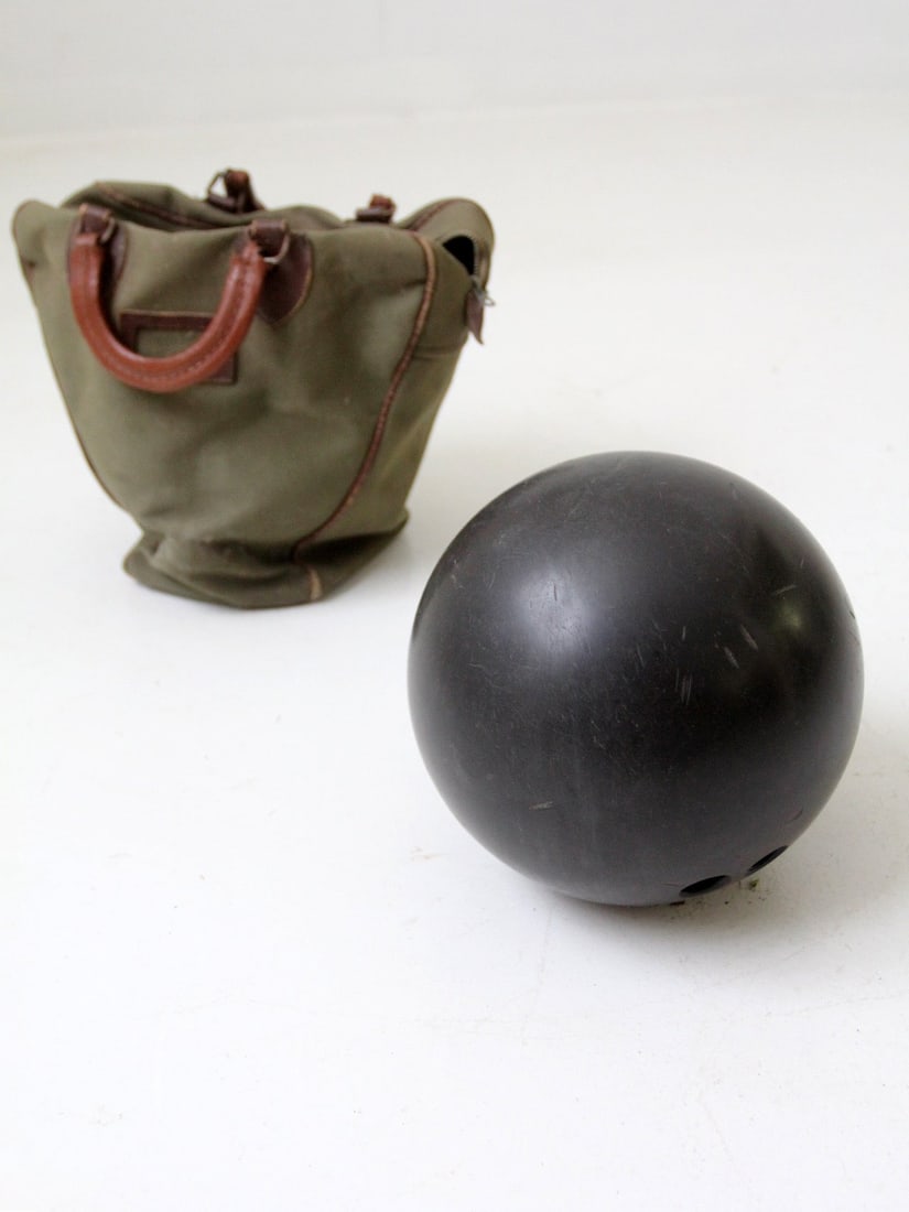Vintage 16 Lb Ebonite Bowling Ball with Green Canvas Bag: Vintage 16 Lb Ebonite Bowling Ball with Green Canvas Bag This vintage 16 lb Ebonite bowling ball, dating back to the 1960s, showcases a matte black hard rubber surface adorned with a classic engraved