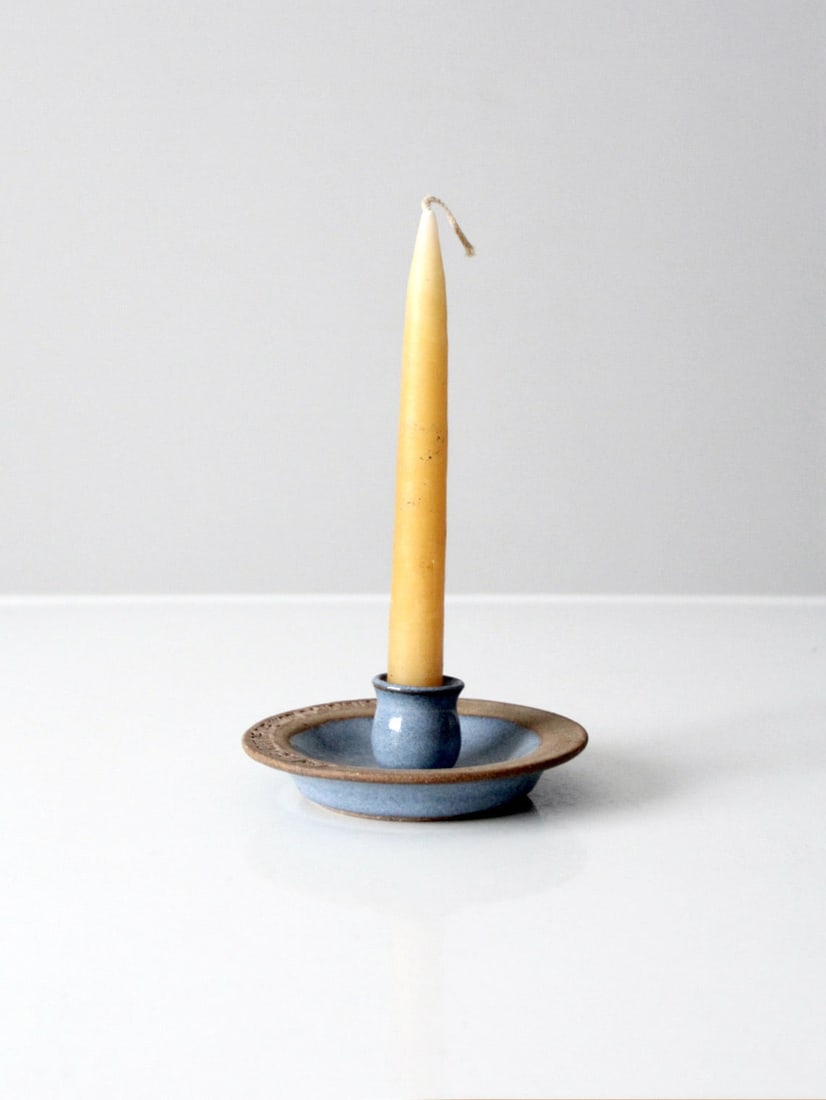 Artisan Vintage Pottery Candlestick with Verse John 9:5: Artisan Vintage Pottery Candlestick with Verse John 9:5 This vintage studio pottery candlestick holder showcases a lovely soft blue glaze that gracefully transitions into a warm, unglazed rim. Embelli