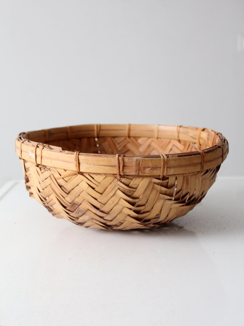 Vintage Honey-Toned Rattan Bowl with Herringbone Weave: Vintage Honey-Toned Rattan Bowl with Herringbone Weave Enhance your home decor with this Vintage Rattan Basket Bowl, showcasing a natural honey-toned finish and a classic herringbone weave. Its light