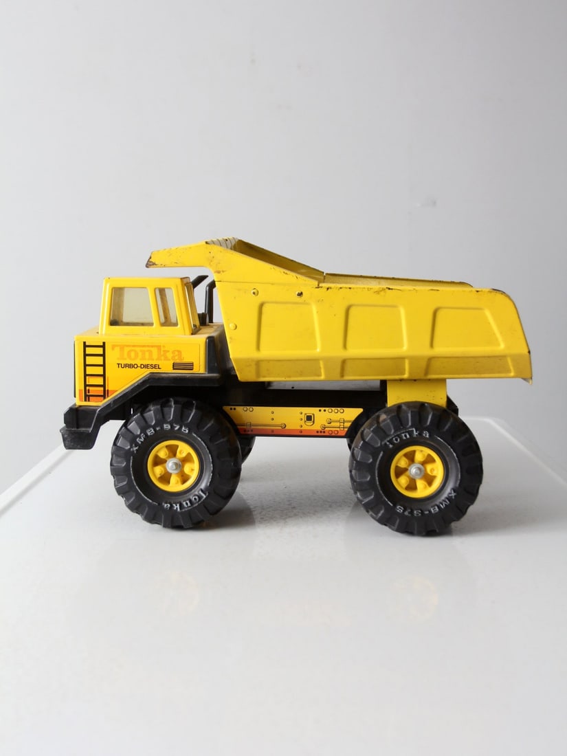 Vintage Tonka XMB-975 Dump Truck Metal Body Yellow: Vintage Tonka XMB-975 Dump Truck Metal Body Yellow This vintage Tonka XMB-975 dump truck boasts a durable metal body and rugged design, featuring a tilting bed for display. Finished in a vibrant const