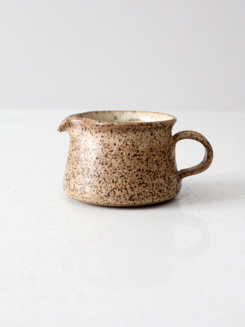 Handmade Vintage Studio Pottery Creamer Pitcher 1981: Handmade Vintage Studio Pottery Creamer Pitcher 1981 This vintage studio pottery creamer pitcher, signed and dated 1981, showcases a beautifully handmade design with a speckled tan glaze that emits a