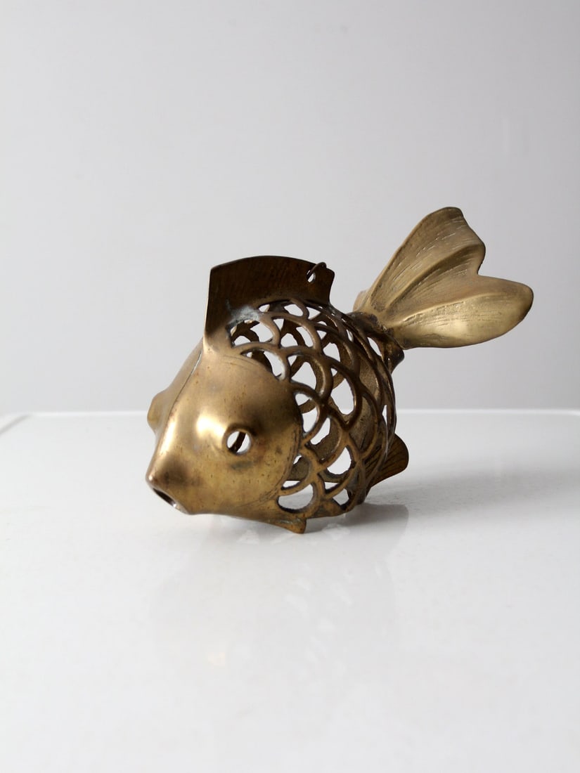 Whimsical Mid-Century Brass Fish Decorative Figure: Whimsical Mid-Century Brass Fish Decorative Figure This mid-20th century brass fish figure showcases a whimsical design featuring an open "scale" body complemented by a solid face and tail. A small ri