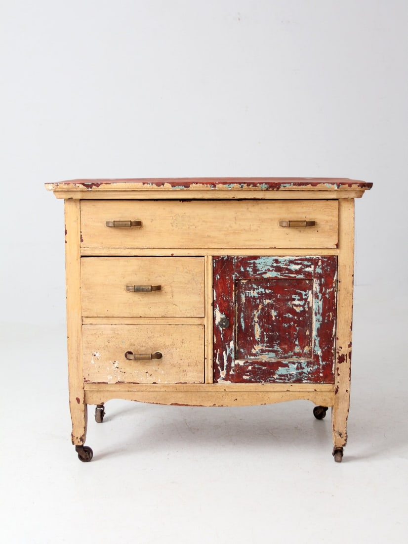 Rustic Antique Primitive Cabinet with 3 Shelves and Casters: Rustic Antique Primitive Cabinet with 3 Shelves and Casters This antique primitive cabinet showcases rustic charm with its weathered paint finish and original hardware. The spacious interior includes