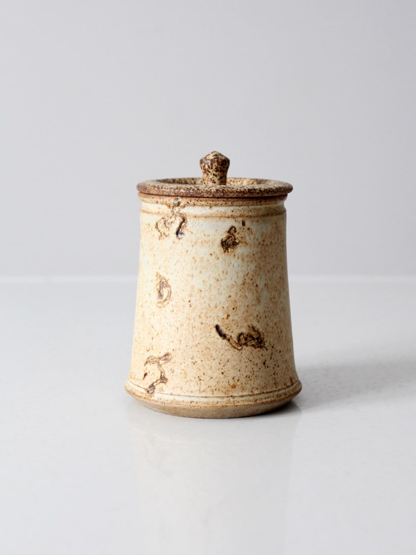 Vintage Earthy Studio Pottery Jar with Etched Detail: Vintage Earthy Studio Pottery Jar with Etched Detail This vintage studio pottery jar showcases a beautiful earthy speckled tan glaze, complemented by etched detailing on one side and a charming small