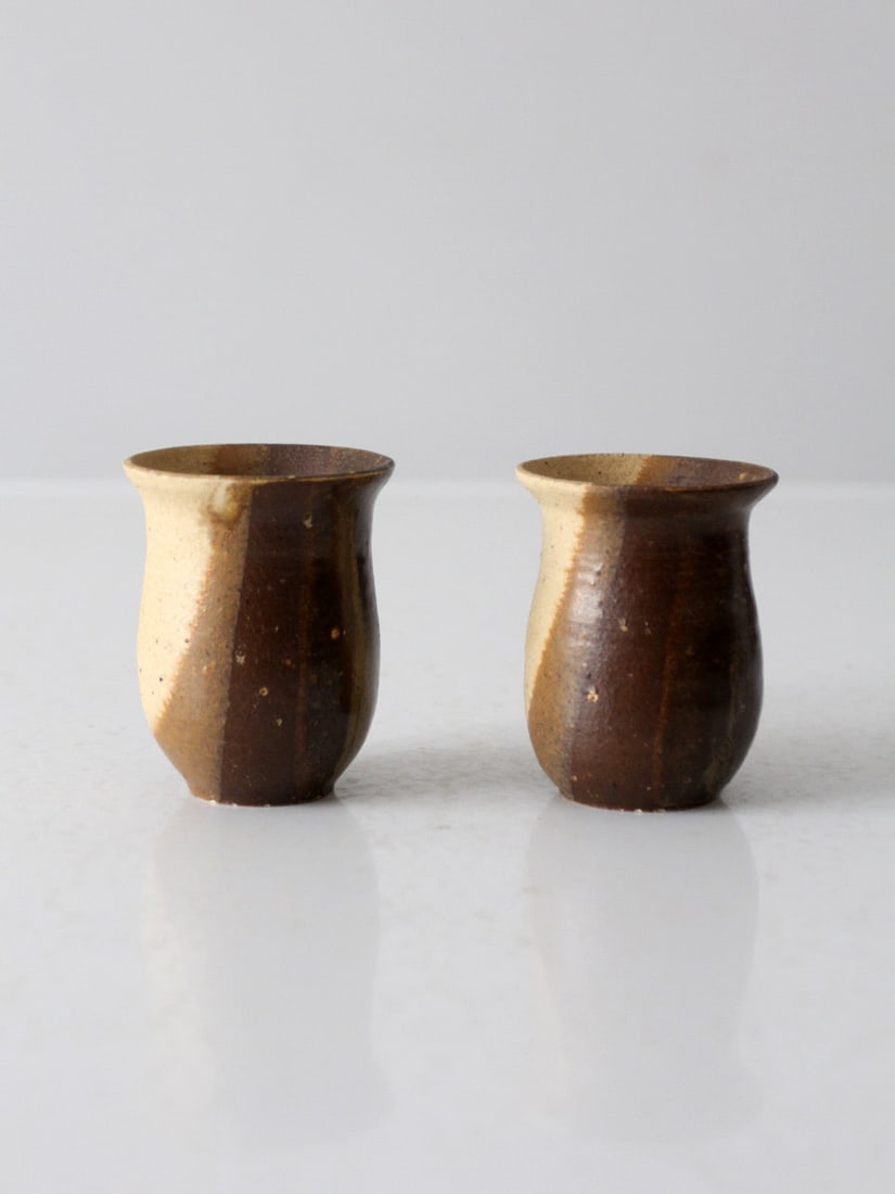 Handmade Vintage Studio Pottery Cups Pair Brown Tan Glaze: Handmade Vintage Studio Pottery Cups Pair Brown Tan Glaze This charming pair of vintage studio pottery cups showcases unique handmade craftsmanship. The fluted vessels feature a beautiful brown and ta