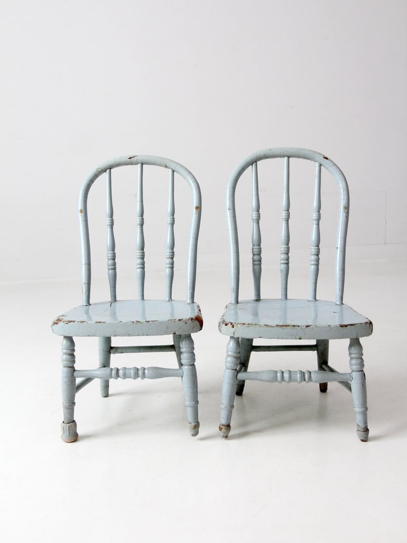Charming Pair of Vintage Spindle Back Kids Chairs: Charming Pair of Vintage Spindle Back Kids Chairs This charming pair of vintage kids' spindle back chairs features a delightful light blue paint that has gracefully worn away, revealing the natural wo