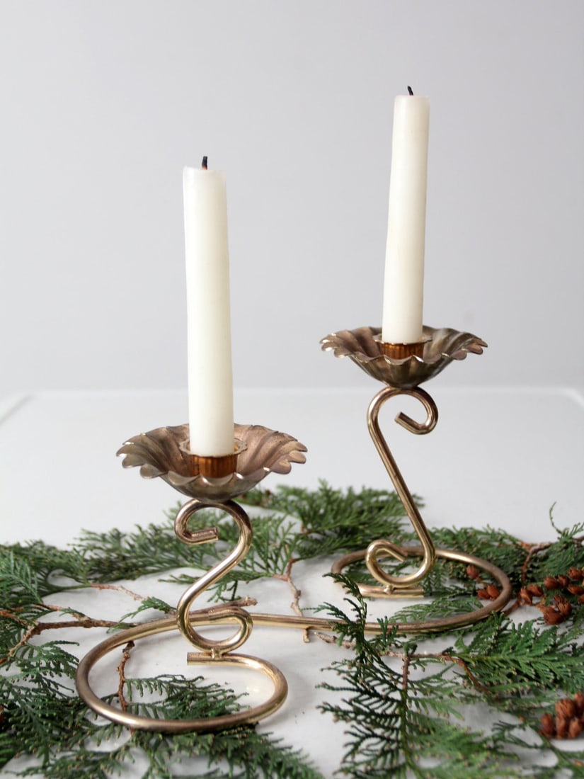 Elegant Vintage Brass Double Candleholder with Flower Base: Elegant Vintage Brass Double Candleholder with Flower Base This vintage brass double candlestick holder features an elegant flower-shaped base and a gracefully curved stem that connects two candle hol