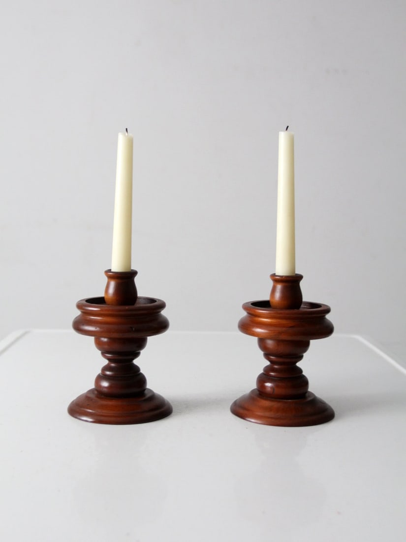 Pair of Vintage American Style Turned Wood Candle Holders: Pair of Vintage American Style Turned Wood Candle Holders This pair of vintage wooden candlestick holders showcases richly turned forms inspired by traditional American design. With their layered prof