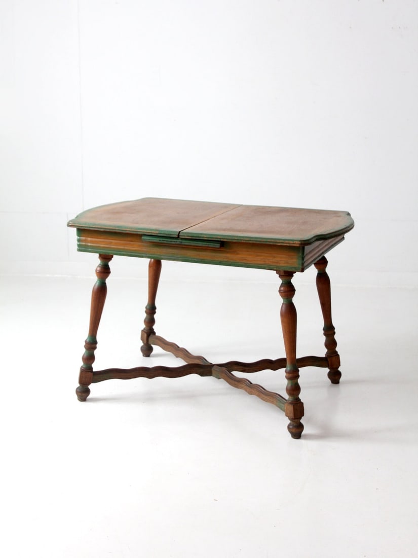 Vintage 1940s Farmhouse Table with Self-Storing Leaf Green Trim: Vintage 1940s Farmhouse Table with Self-Storing Leaf Green Trim This vintage kitchen table, dating back to circa 1940, beautifully embodies the rustic charm of a farmhouse style. It features a self-st