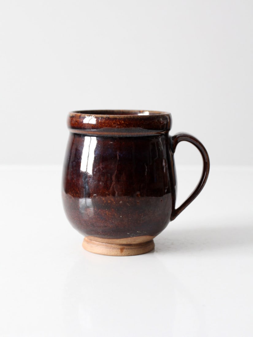 Cascio Signed Vintage Studio Pottery Mug Deep Brown Glaze: Cascio Signed Vintage Studio Pottery Mug Deep Brown Glaze This vintage studio pottery mug, signed by the artist Cascio, showcases a unique hand-crafted design with a deep brown glaze and an unglazed p