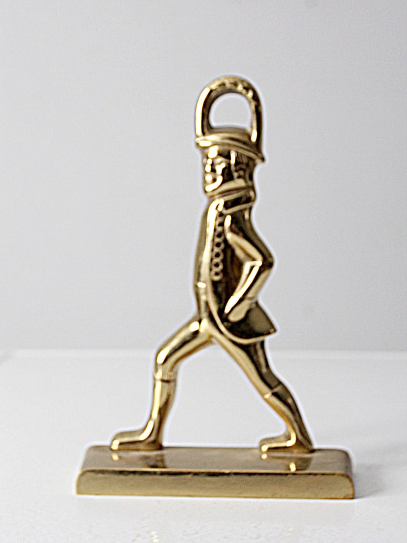Vintage Brass Colonial Soldier Doorstop by Virginia Metalcrafters: Vintage Brass Colonial Soldier Doorstop by Virginia Metalcrafters This vintage Virginia Metalcrafters doorstop, crafted from brass in the 1960s, features a detailed design of a Colonial Williamsburg H