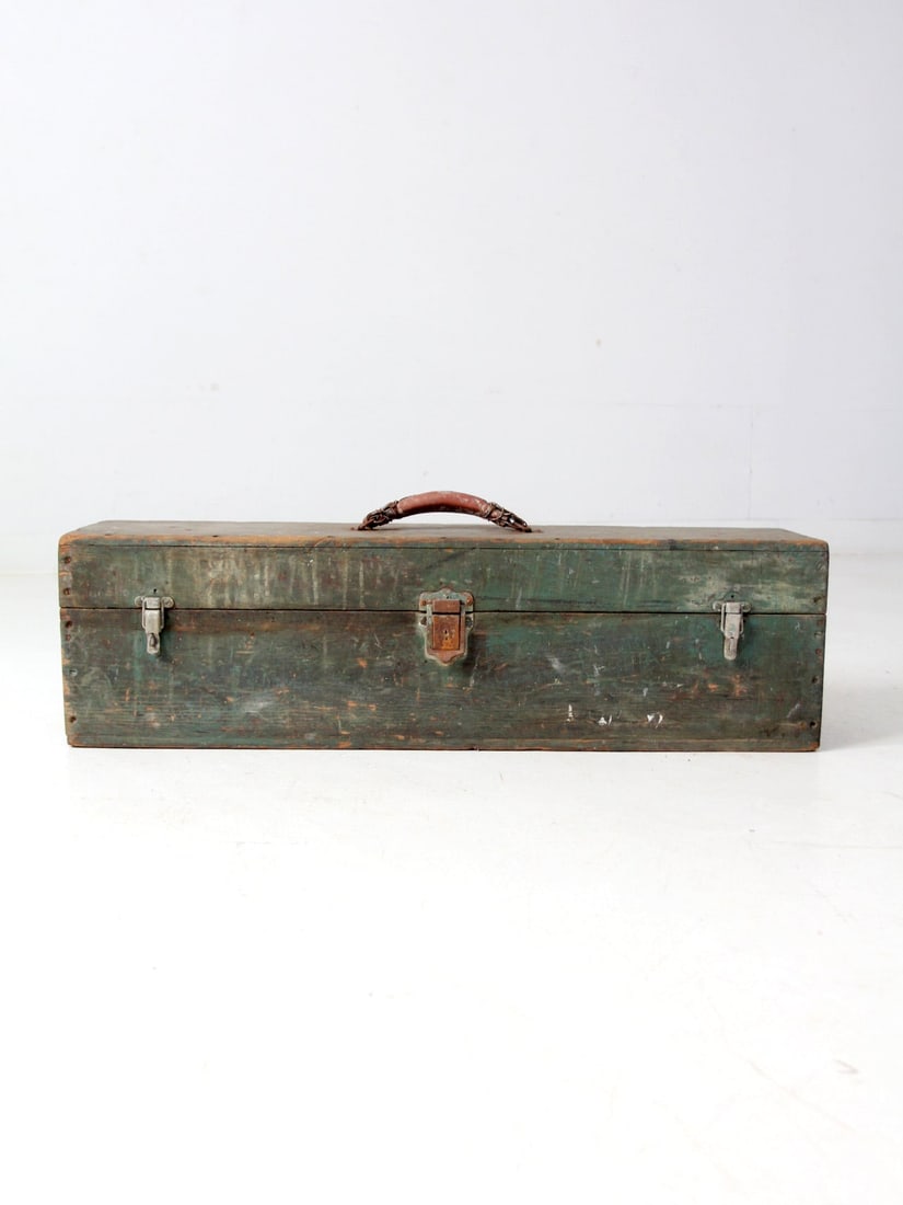 Vintage Green Wooden Toolbox with Leather Handle: Vintage Green Wooden Toolbox with Leather Handle Enhance your workspace or home decor with this vintage wooden toolbox, exuding timeless industrial charm. It features a weathered green finish, a leath