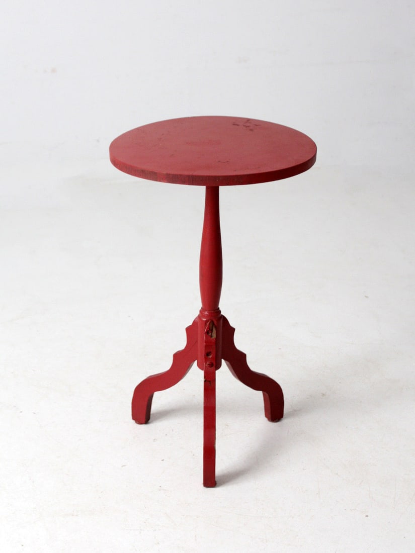 Vintage Red Pedestal Table with Tripod Base 25.75 in Height: Vintage Red Pedestal Table with Tripod Base 25.75 in Height This vintage red pedestal table showcases a charming tripod base complemented by a rustic red finish, adding character to any room. It serve