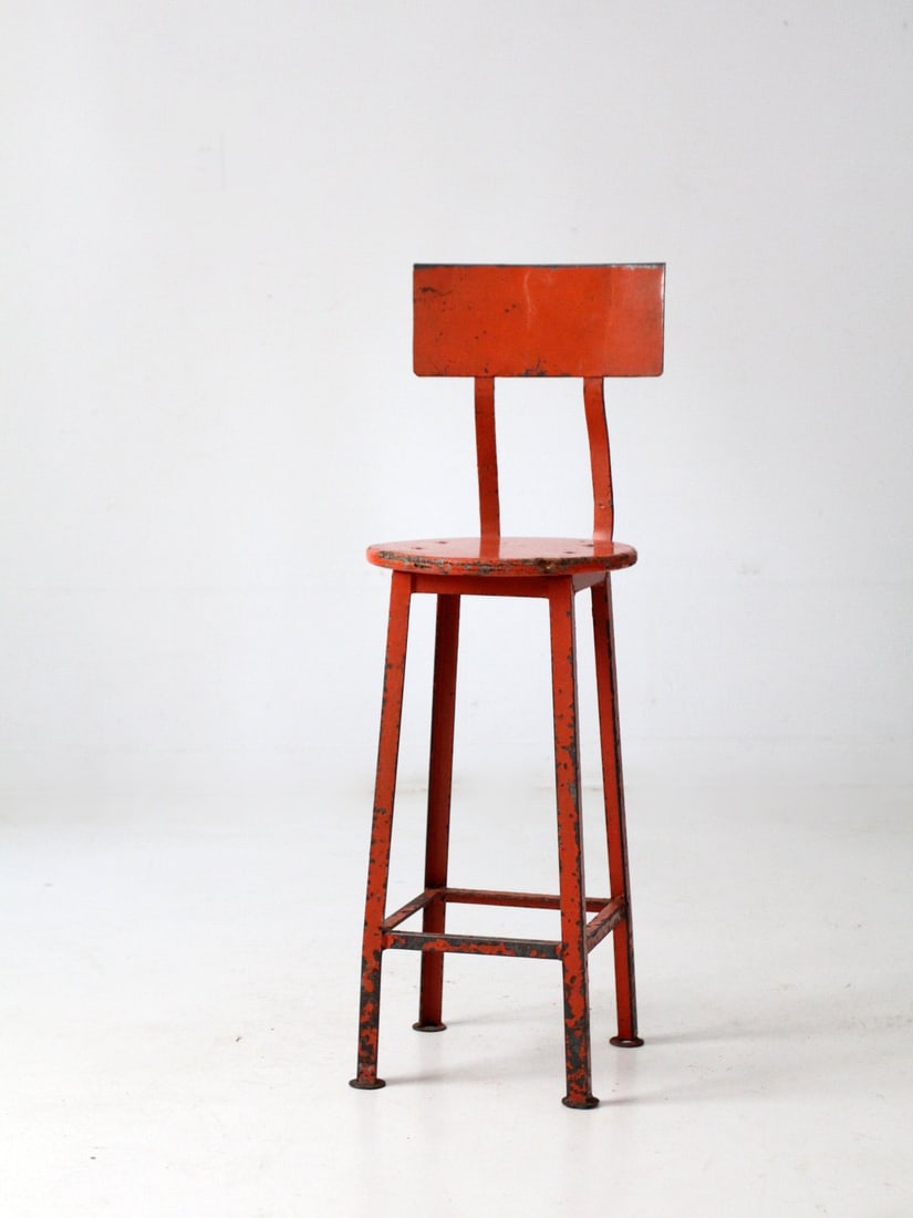 Orange Metal Frame Vintage Stool with Wooden Seat and Backrest: Orange Metal Frame Vintage Stool with Wooden Seat and Backrest This vintage industrial stool features a bold orange metal frame, a round wooden seat, and a gently arched backrest for added support. It