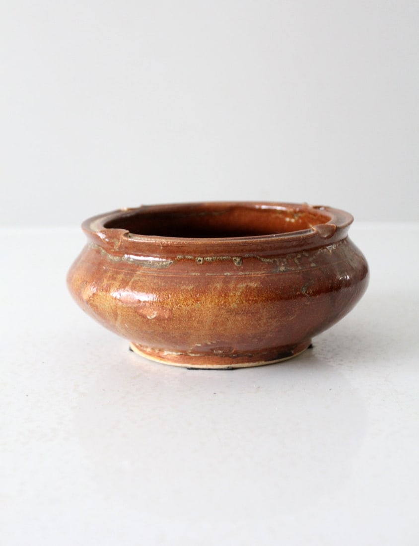 Handcrafted Vintage Pottery Bowl with Rim Notches 7.25 inch: Handcrafted Vintage Pottery Bowl with Rim Notches 7.25 inch This handcrafted vintage pottery bowl features a warm glaze and four distinctive rim notches, adding a touch of rustic charm to any setting.