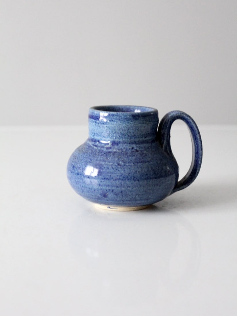 Artist Signed Vintage Studio Pottery Mug with Blue Glaze: Artist Signed Vintage Studio Pottery Mug with Blue Glaze This vintage art studio pottery mug showcases exquisite craftsmanship with its stunning blue glaze and a generously sized handle, perfect for c