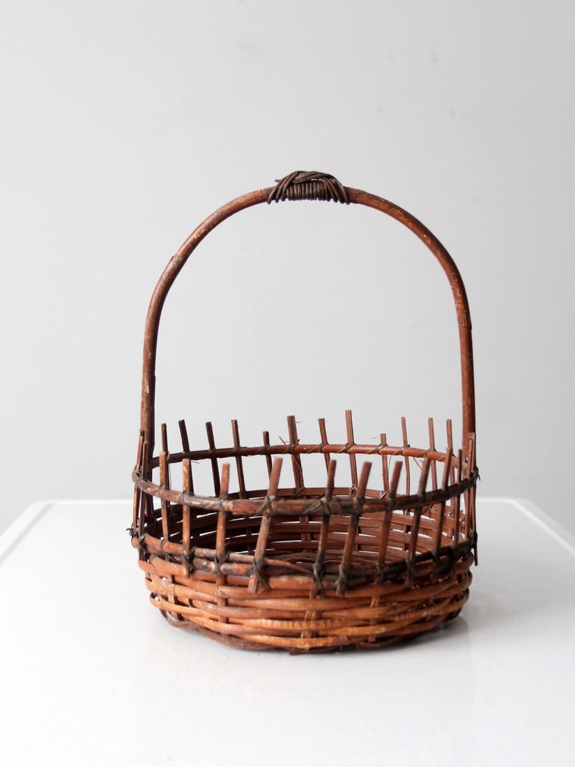 Charming Vintage Rustic Wicker Basket with Bentwood Handle: Charming Vintage Rustic Wicker Basket with Bentwood Handle Discover this charming vintage wicker basket that adds a rustic touch to any space. Its open fenced design top enhances its unique character,