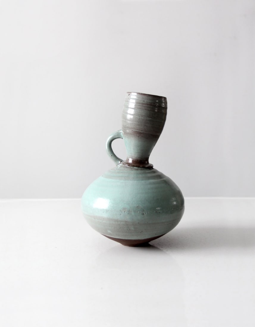 Vintage Studio Art Pottery Topsy-Turvy Vase in Turquoise Glaze: Vintage Studio Art Pottery Topsy-Turvy Vase in Turquoise Glaze This vintage studio art pottery tilted vase showcases a captivating design with a soft turquoise glaze and an asymmetrical neck. Its bulb