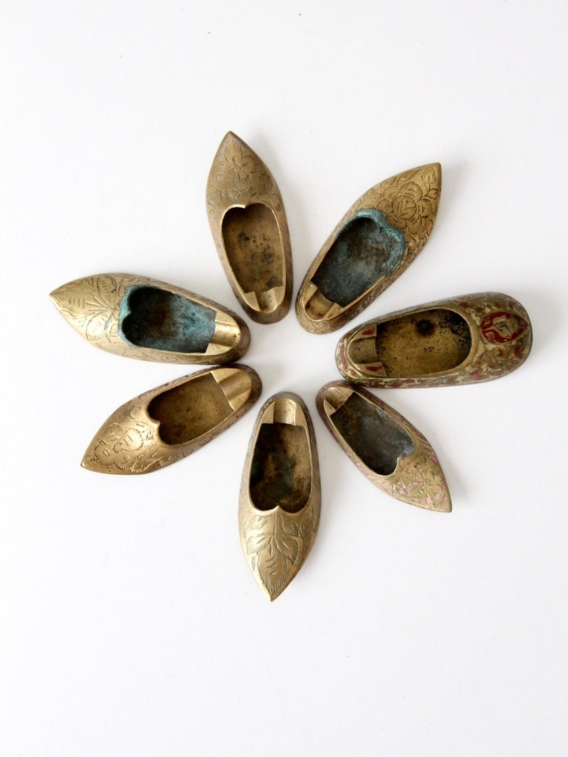 Set of Brass Floral Engraved Shoe Shaped Midcentury Ashtrays: Set of Brass Floral Engraved Shoe Shaped Midcentury Ashtrays This set of mid-20th century brass ashtrays features a unique shoe form, each engraved with intricate floral patterns and finished with a r