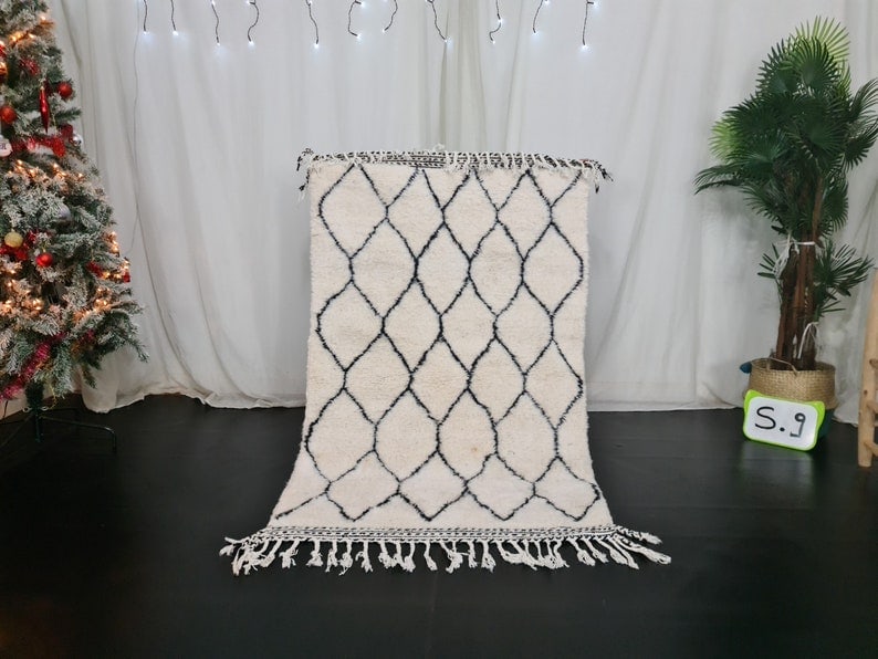 Authentic Moroccan Berber Wool Rug 3.28 x 5 Feet Handmade: Authentic Moroccan Berber Wool Rug 3.28 x 5 Feet Handmade Discover the elegance of this authentic white handmade Moroccan Berber wool rug, featuring a striking black geometric pattern. Crafted by skil