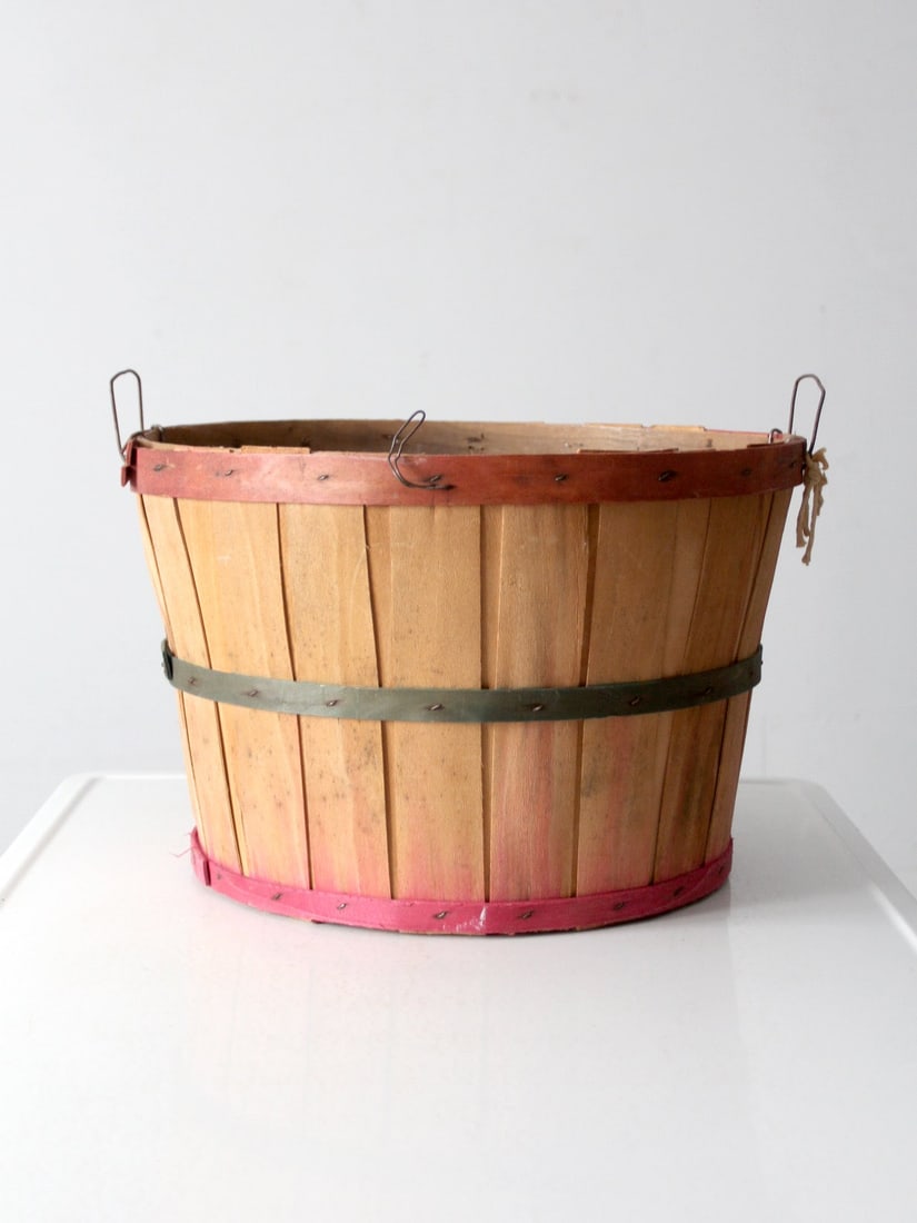 Vintage Apple Orchard Bushel Basket with Metal Handles: Vintage Apple Orchard Bushel Basket with Metal Handles This vintage apple orchard bushel basket showcases a charming light wood paneling accented with slender red and green binding strips, complemente