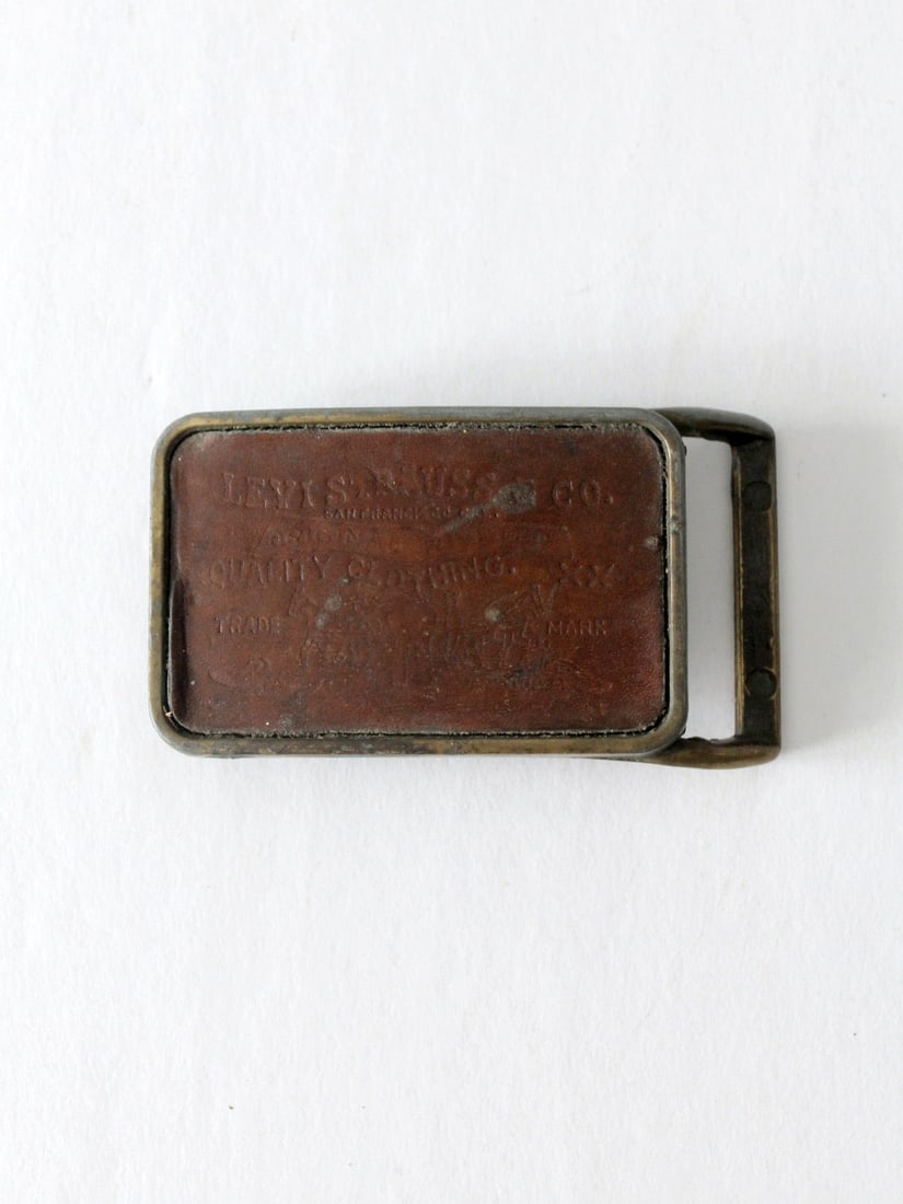1970s Vintage Levi's Brass Belt Buckle with Leather Inlay: 1970s Vintage Levi's Brass Belt Buckle with Leather Inlay Discover this authentic vintage 1970's Levi's belt buckle, crafted from brass and featuring an original Levi's Strauss leather inlay. The bras