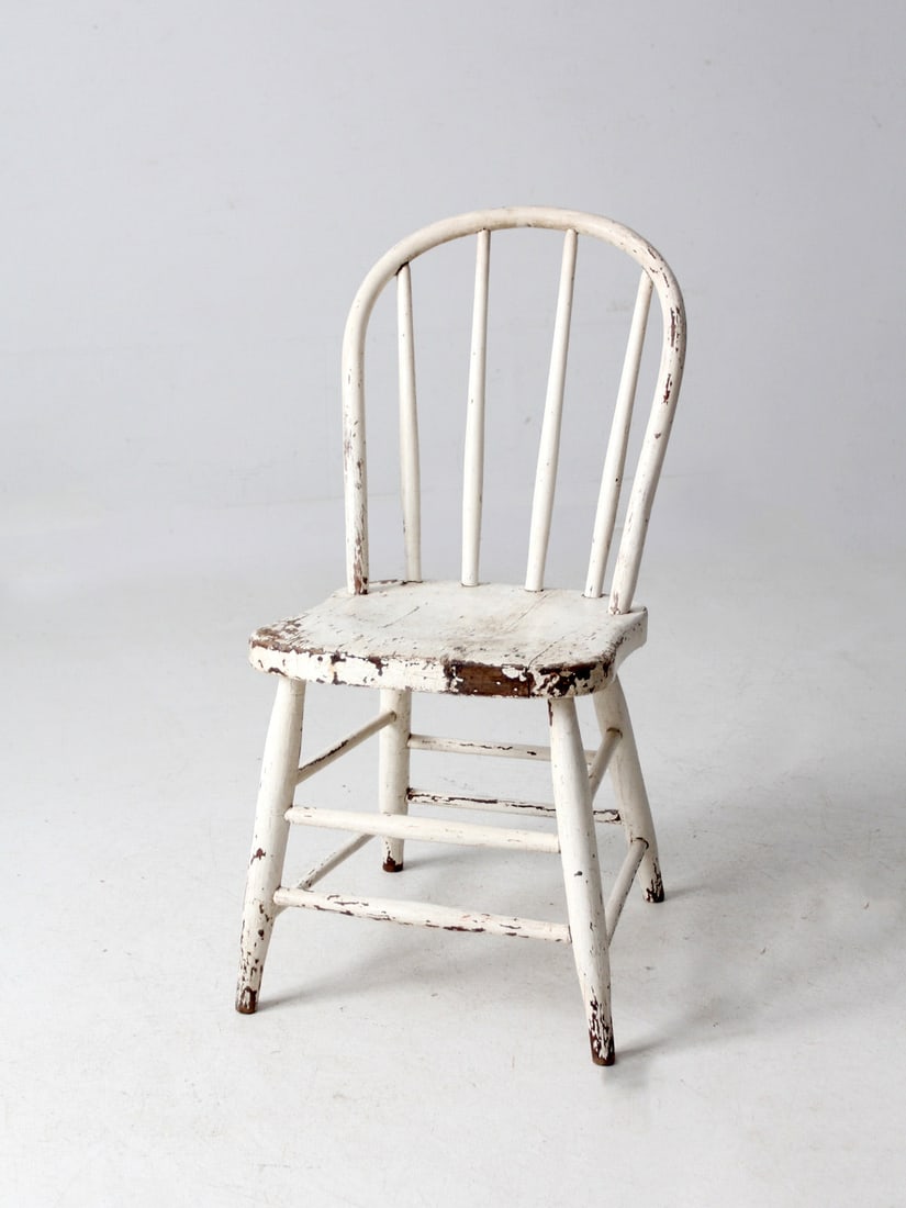 Antique Farmhouse Spindle Back Chair with Rustic White Finish: Antique Farmhouse Spindle Back Chair with Rustic White Finish This charming antique farmhouse chair showcases a beautifully bowed spindle back and elegantly splayed legs, all enhanced by a naturally a