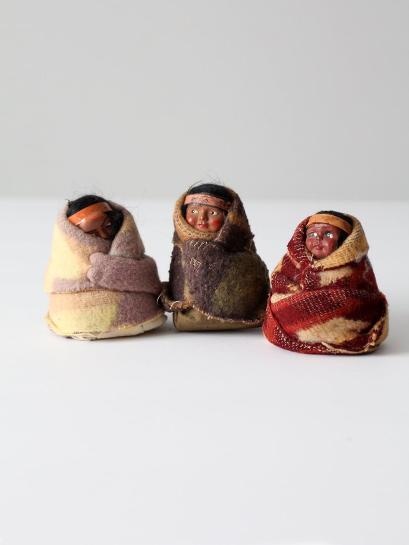Collection of 3 Vintage Skookum Dolls with Indian Blankets: Collection of 3 Vintage Skookum Dolls with Indian Blankets This collection features three vintage Skookum dolls from the early to mid-20th century, designed as tourist souvenirs. Each doll showcases a