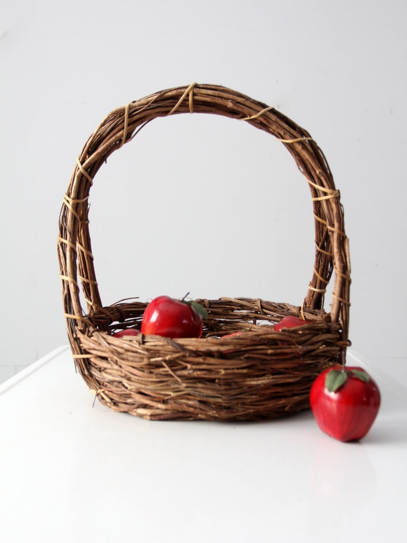 Adirondack Style Vintage Wicker Basket with Twig Handle: Adirondack Style Vintage Wicker Basket with Twig Handle This vintage rustic wicker basket features a charming Adirondack style, crafted from woven wicker twigs and complemented by a bound twig handle.