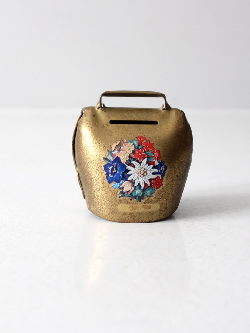 Charming Vintage Brass Hand-Painted Cowbell Bank Decorative Accent: Charming Vintage Brass Hand-Painted Cowbell Bank Decorative Accent This vintage brass cowbell bank is adorned with a charming hand-painted floral design, making it a delightful decorative piece for an