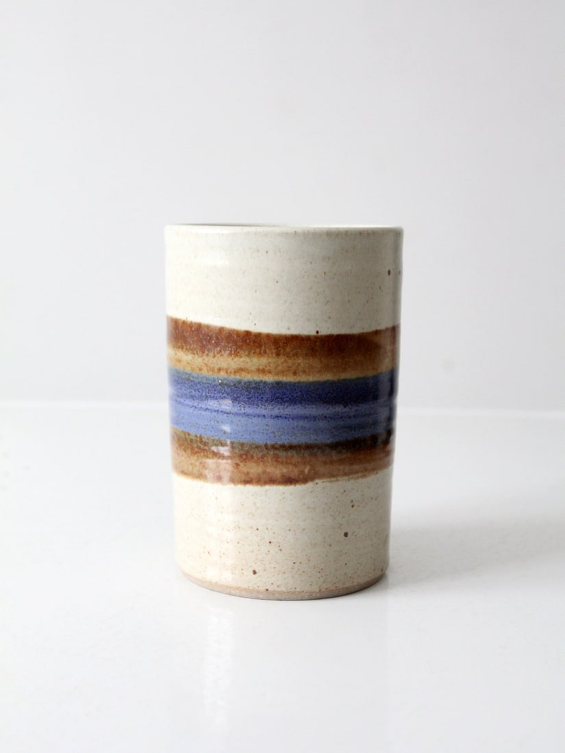 Handmade Vintage Studio Pottery Vase with Earthy Brown and Blue Bands: Handmade Vintage Studio Pottery Vase with Earthy Brown and Blue Bands This vintage studio pottery vase showcases a tall cylindrical shape adorned with horizontal bands of earthy brown and deep blue, s