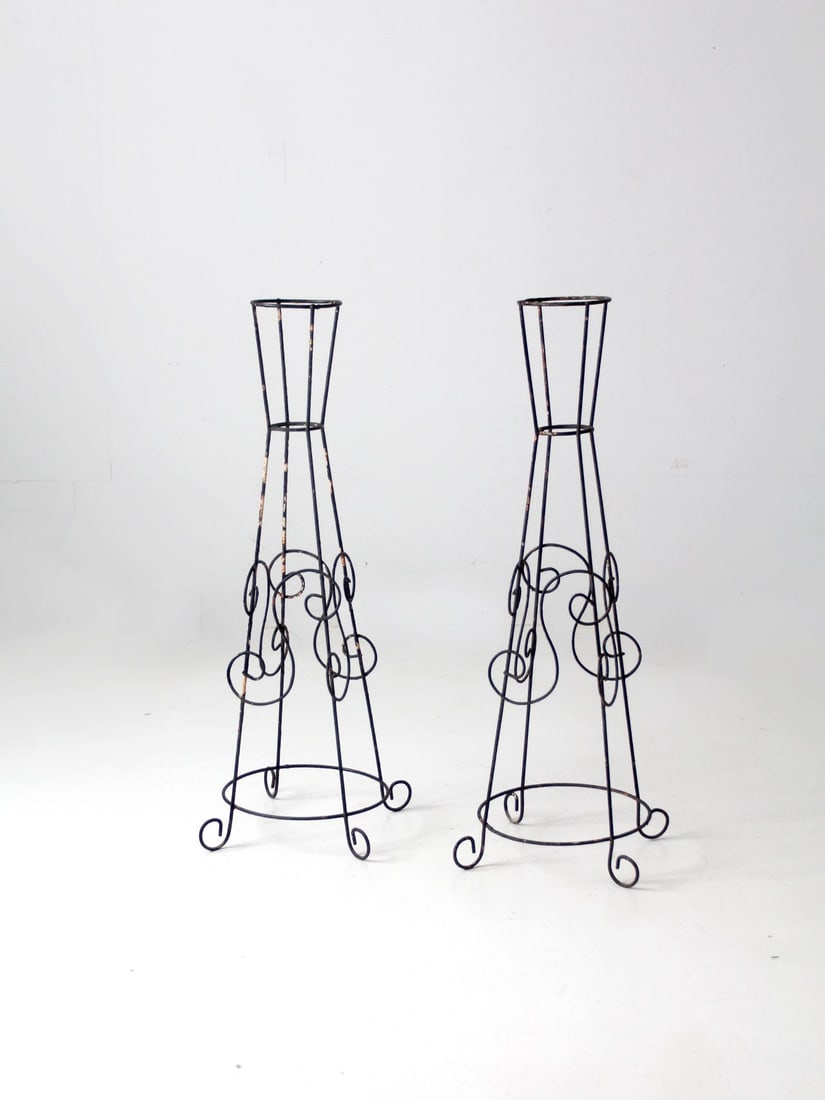 Vintage Mid Century Black Iron Plant Stands Pair with Curved Design: Vintage Mid Century Black Iron Plant Stands Pair with Curved Design This pair of mid-20th century iron plant stands showcases elegant curling and curving designs, perfect for displaying pots or lanter