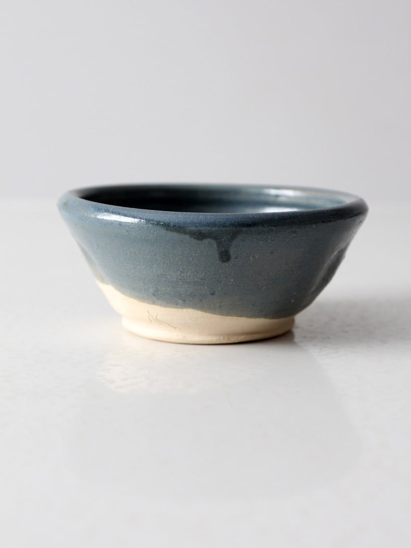 Handmade Vintage Pottery Bowl with Blue Glaze and Pinched Design: Handmade Vintage Pottery Bowl with Blue Glaze and Pinched Design This vintage handmade pottery bowl features a stunning dipped blue glaze that beautifully contrasts with the natural clay exposed at th