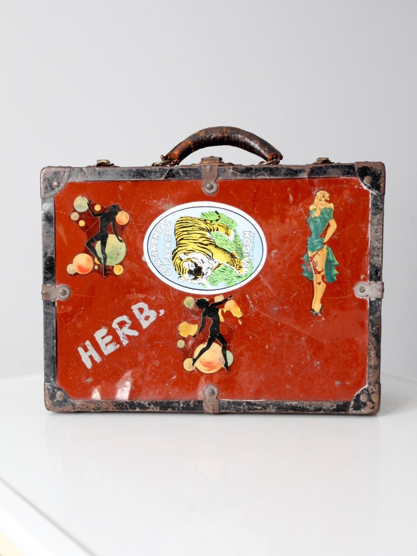 Vintage Red and White Metal Luggage Case with Stickers: Vintage Red and White Metal Luggage Case with Stickers Discover a unique piece of travel history with this vintage metal luggage case. This eye-catching red and white metal bag is accented with black
