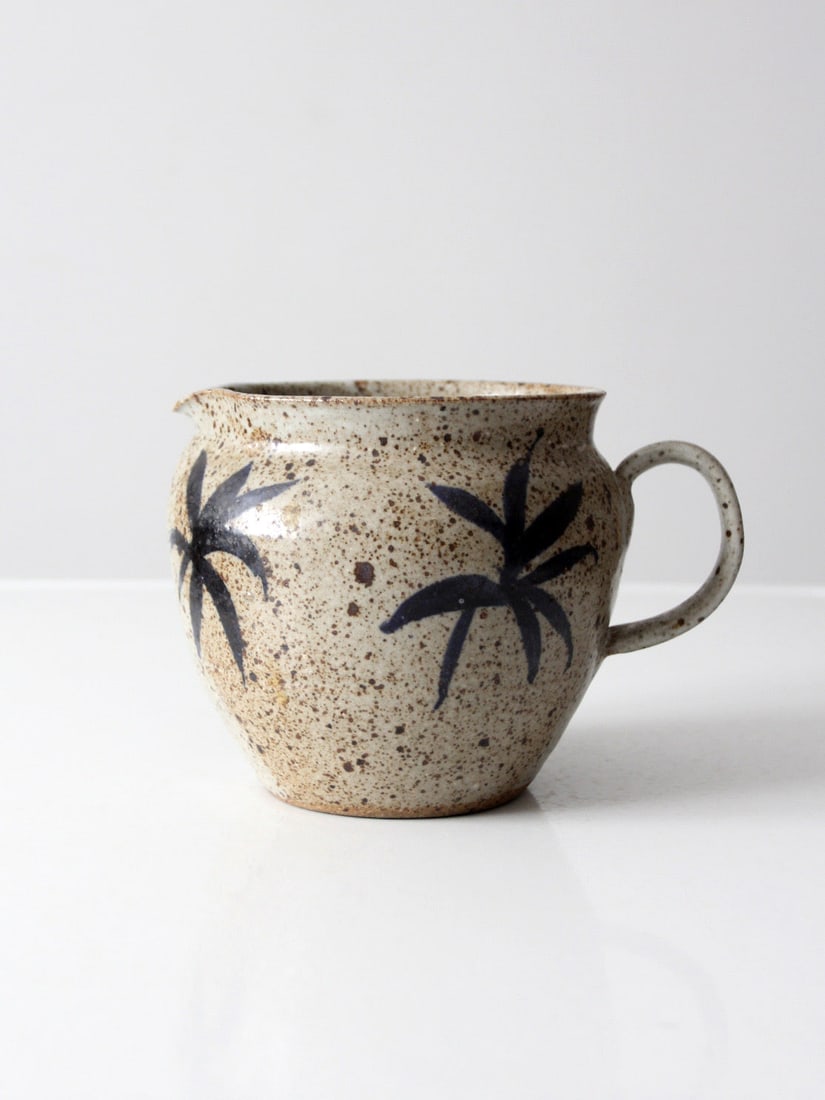 Handmade Studio Pottery Cream Glazed Pitcher with Palm Motif Signed: Handmade Studio Pottery Cream Glazed Pitcher with Palm Motif Signed This vintage handmade studio pottery pitcher features a rounded, balanced form with a speckled cream glaze and hand-painted palm mot