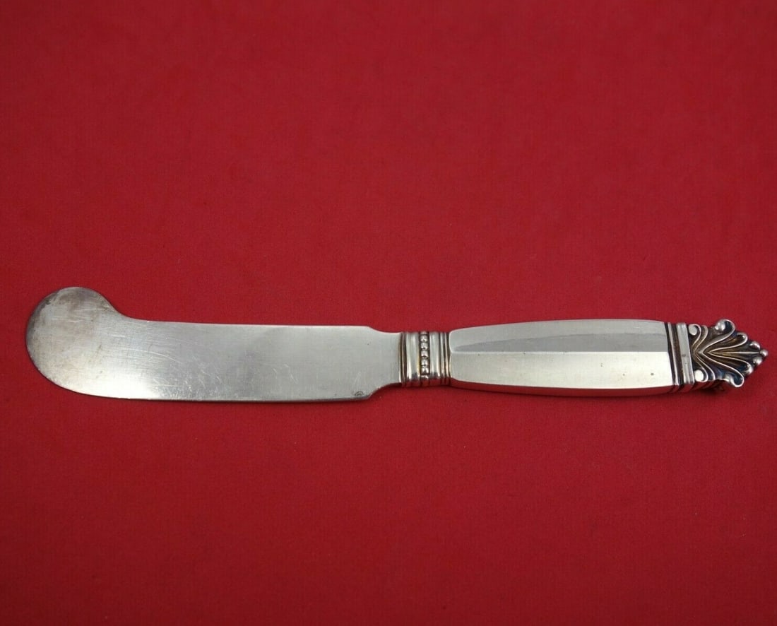 Georg Jensen Acanthus Sterling Silver Butter Knife 7": Georg Jensen Acanthus Sterling Silver Butter Knife 7" This exquisite butter knife from the Acanthus pattern by Georg Jensen features a hollow handle crafted from sterling silver, complemented by a pad