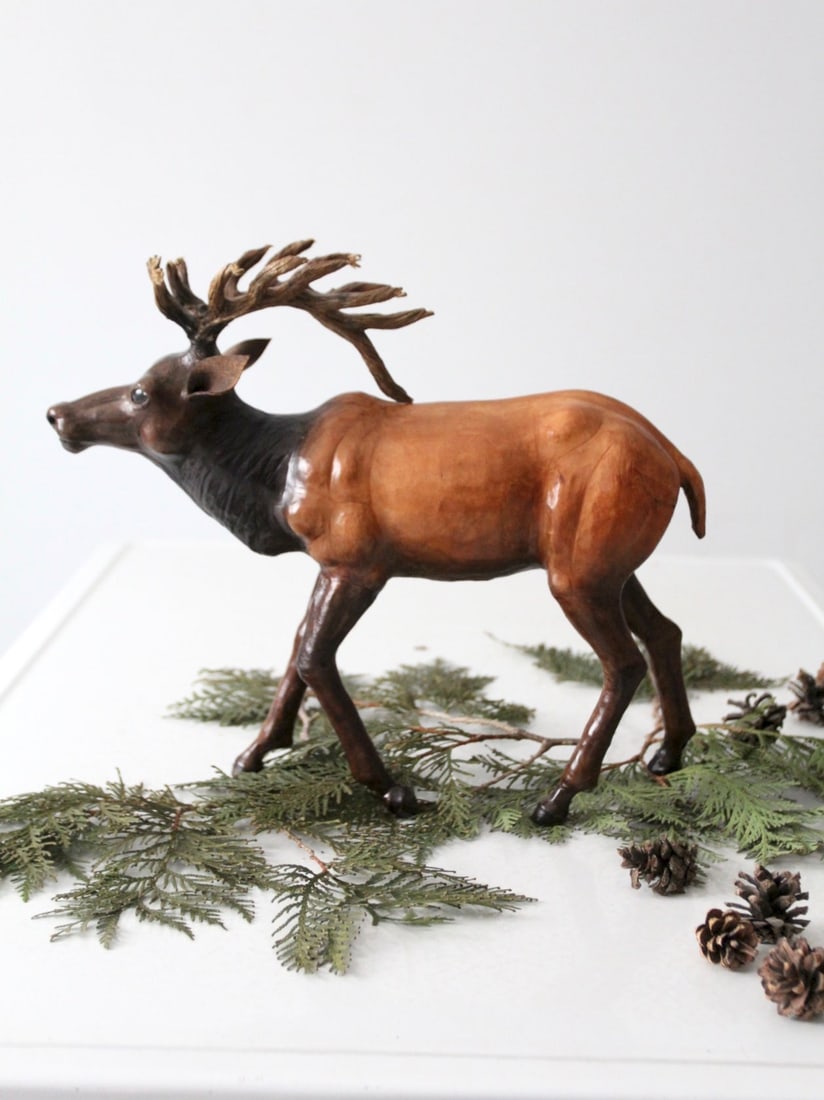 Vintage Leather Reindeer Sculpture 12 inch with Glass Eyes: Vintage Leather Reindeer Sculpture 12 inch with Glass Eyes This vintage leather reindeer sculpture features a beautifully crafted stag with warm, softly varied tones and a lifelike stance. The sculptu