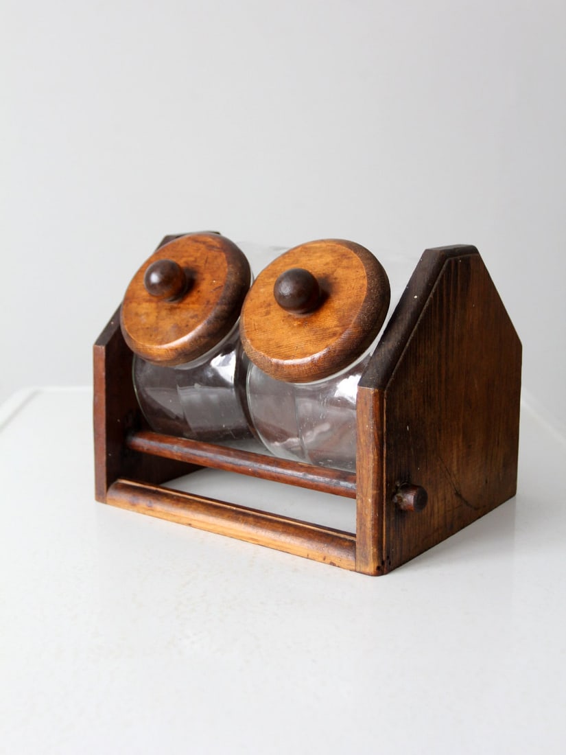 Vintage Glass Jars with Wooden Stand for Kitchen Organization: Vintage Glass Jars with Wooden Stand for Kitchen Organization Enhance your kitchen organization with this charming pair of vintage glass jars, elegantly displayed on a solid wooden stand. Each jar fea